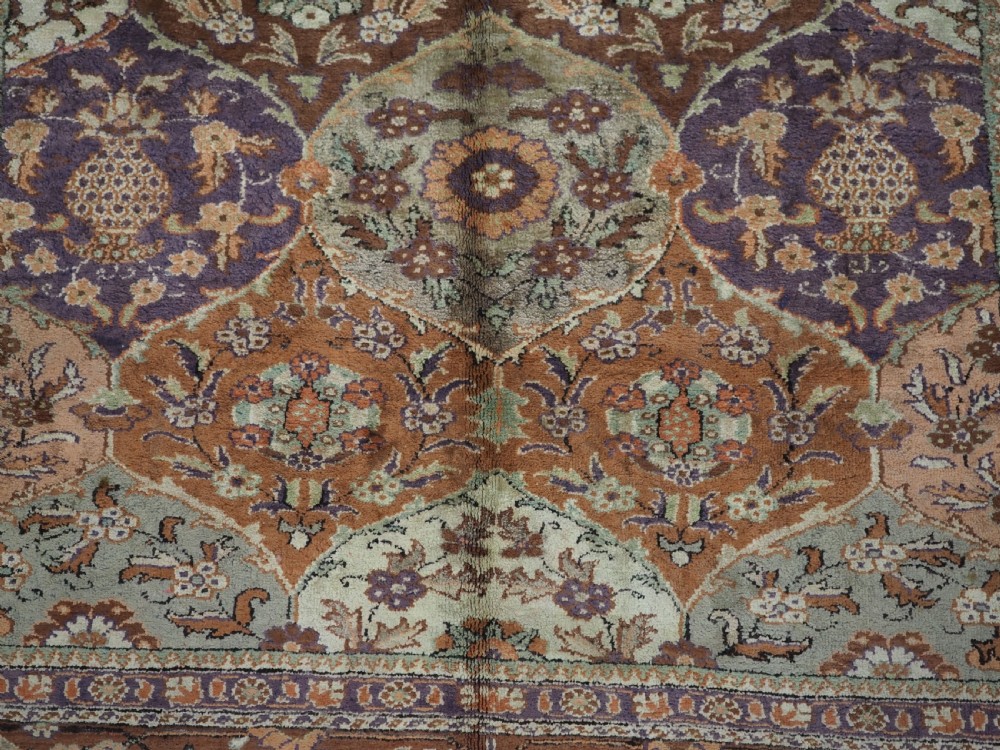 A rectangular vintage Turkish Kayseri rug featuring intricate floral lattice motifs and medallions in shades of brown, terracotta, purple, and green with a decorative bordered edge and fringed ends. View X