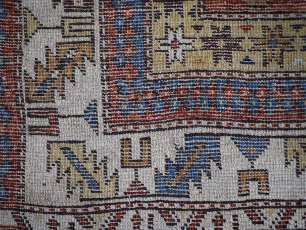 An antique hand-knotted Caucasian Shirvan wool rug with geometric central medallions, zoomorphic figures, and tribal borders in terracotta, cream, and navy blue. View XIV