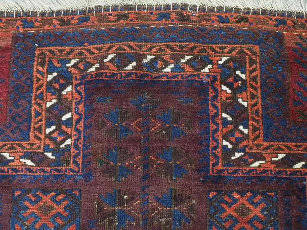 An antique hand-knotted wool prayer rug featuring a defined mihrab arch, geometric box patterns, and deep aubergine, rust red, and indigo blue tones. View VI