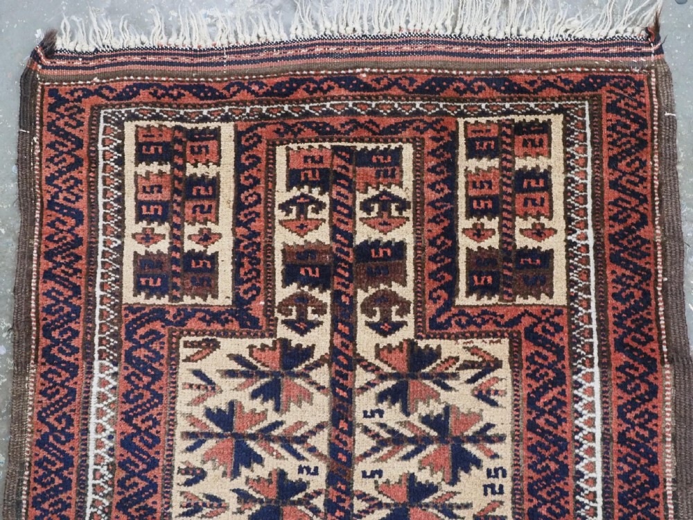 An antique hand-knotted Baluch prayer rug featuring a camel-coloured ground, central tree of life motif, mihrab arch, and decorative geometric borders. View III