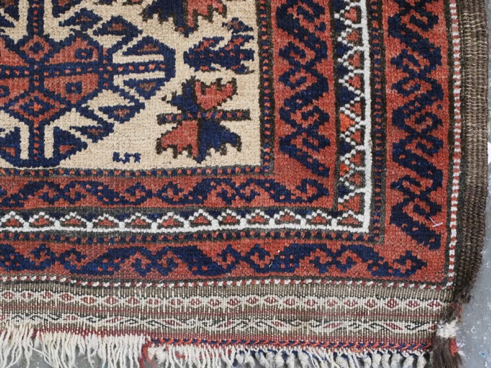 An antique hand-knotted Baluch prayer rug featuring a camel-coloured ground, central tree of life motif, mihrab arch, and decorative geometric borders. View X