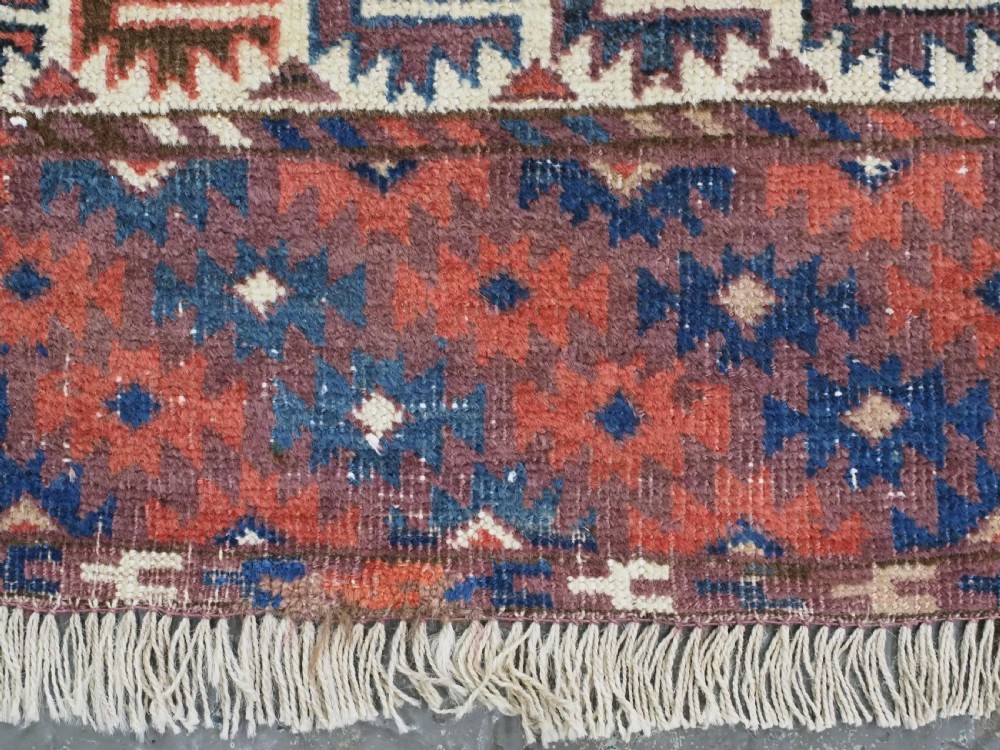 A hand-knotted antique Yomut Turkmen wool rug featuring repeating diamond-shaped geometric guls in red, navy, brown, and cream with patterned borders. View XI