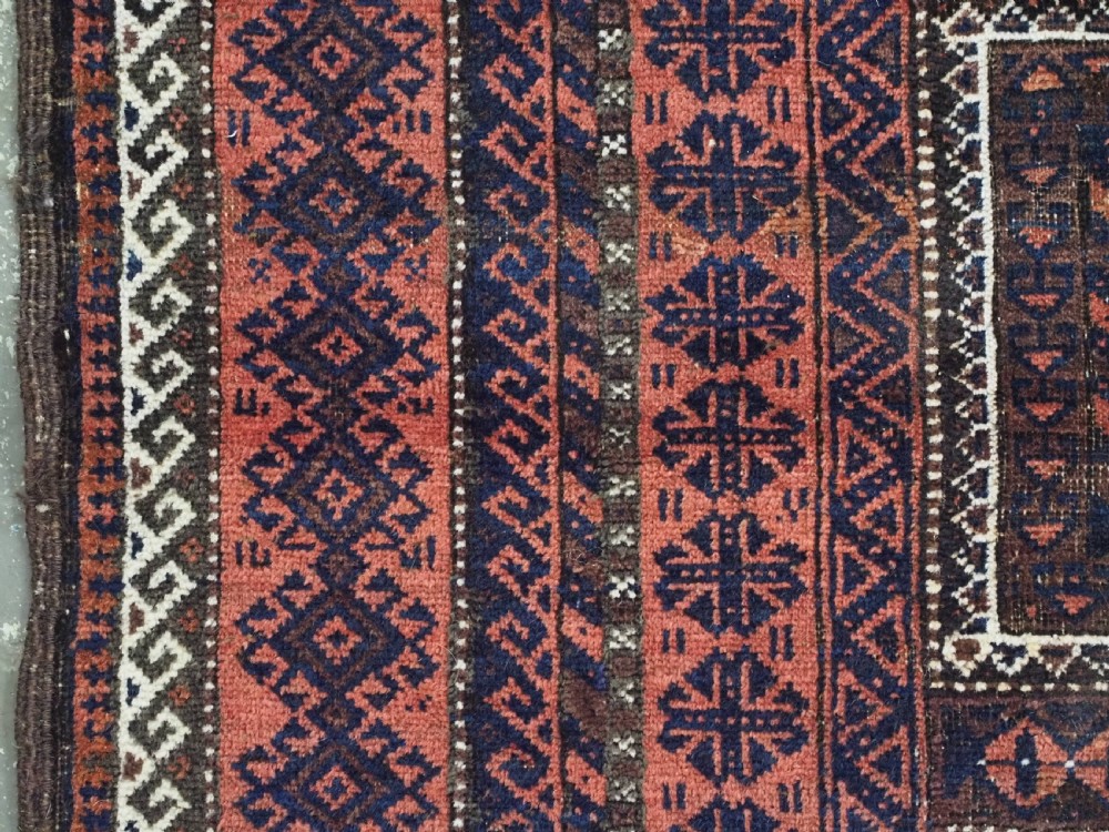 An antique Baluch hand-knotted wool rug featuring five geometric square medallions along a central field in deep red, dark navy blue, and terracotta tones. View VII