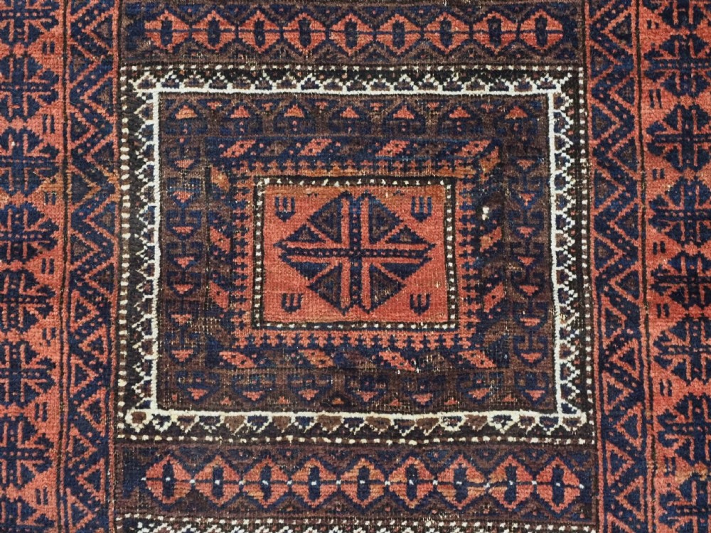 An antique Baluch hand-knotted wool rug featuring five geometric square medallions along a central field in deep red, dark navy blue, and terracotta tones. View IX