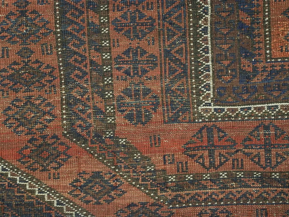 An antique Baluch hand-knotted wool rug featuring five geometric square medallions along a central field in deep red, dark navy blue, and terracotta tones. View XII
