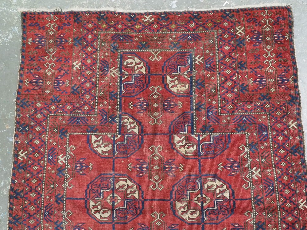 A hand-knotted antique Baluch prayer rug featuring a deep red ground, geometric octagonal medallions, an arched mihrab motif at the top, and multi-band patterned borders. View III