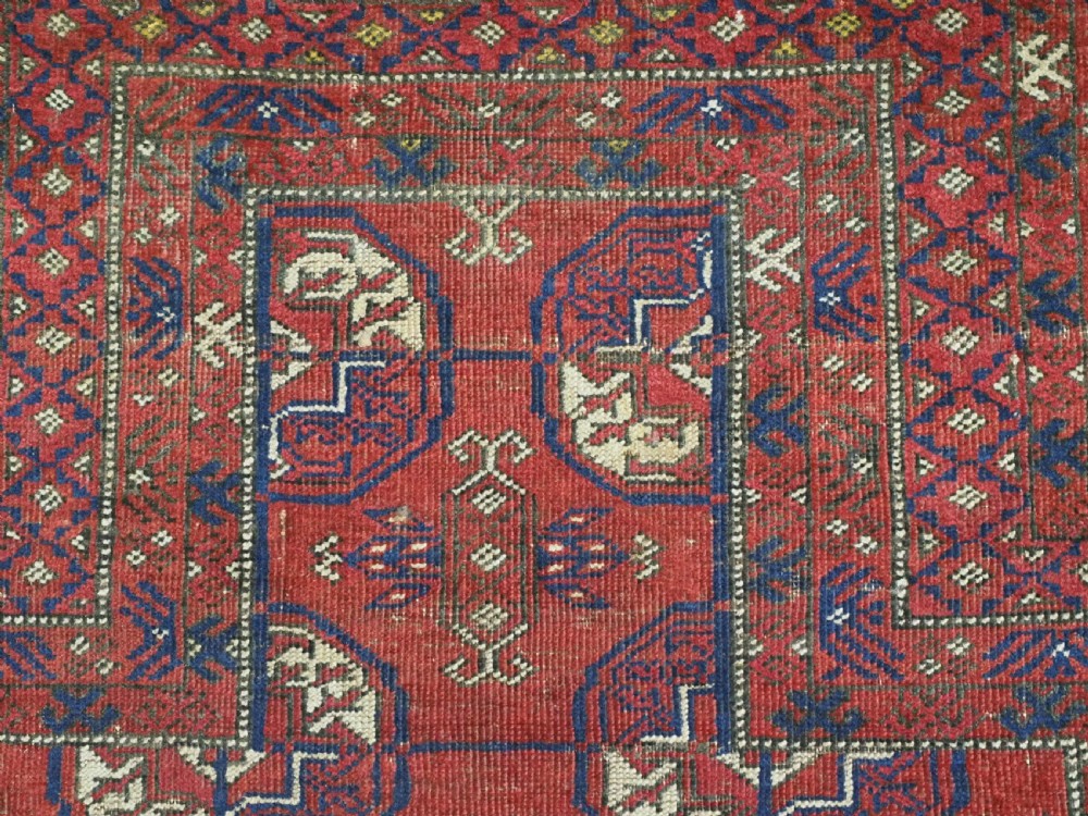 A hand-knotted antique Baluch prayer rug featuring a deep red ground, geometric octagonal medallions, an arched mihrab motif at the top, and multi-band patterned borders. View VIII