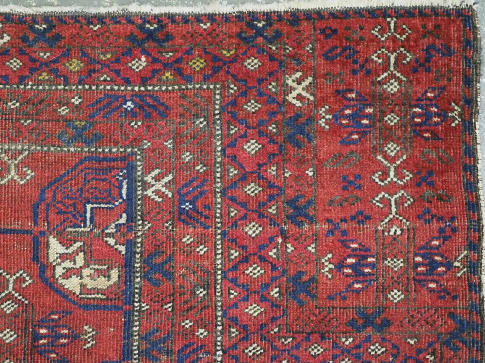 A hand-knotted antique Baluch prayer rug featuring a deep red ground, geometric octagonal medallions, an arched mihrab motif at the top, and multi-band patterned borders. View IX