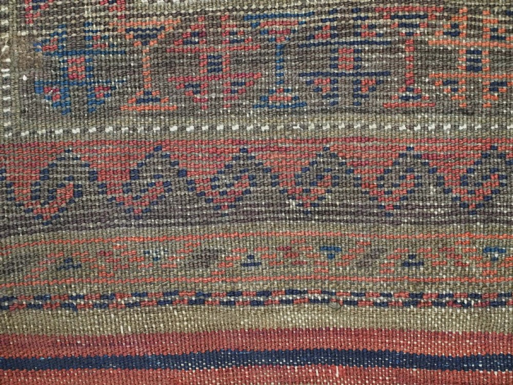 An antique hand-knotted Baluch prayer rug featuring a dark blue central field decorated with geometric motifs framed by a stepped arch and multi-tiered red borders. View XIII