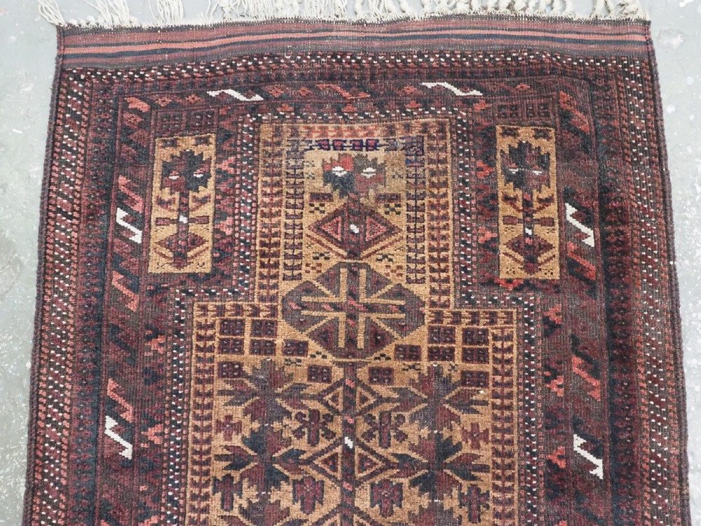 An antique woven Baluch prayer rug with a central tree of life design in camel brown and dark red tones. View III