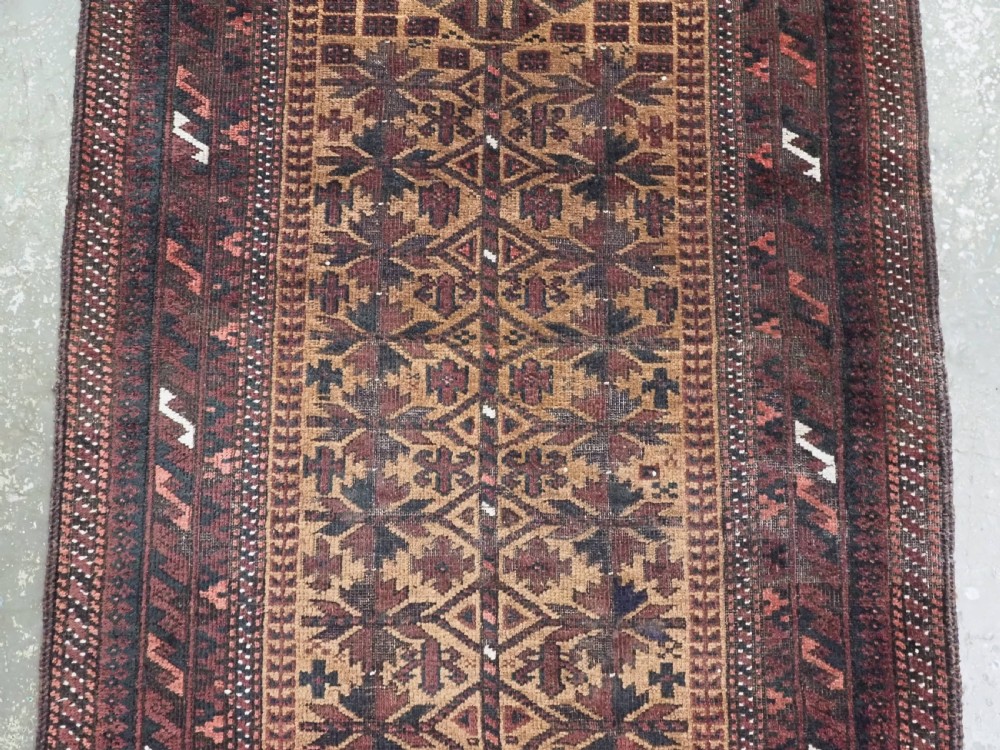 An antique woven Baluch prayer rug with a central tree of life design in camel brown and dark red tones. View IV