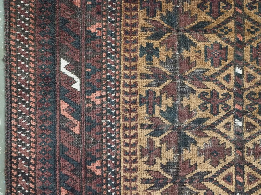 An antique woven Baluch prayer rug with a central tree of life design in camel brown and dark red tones. View VII