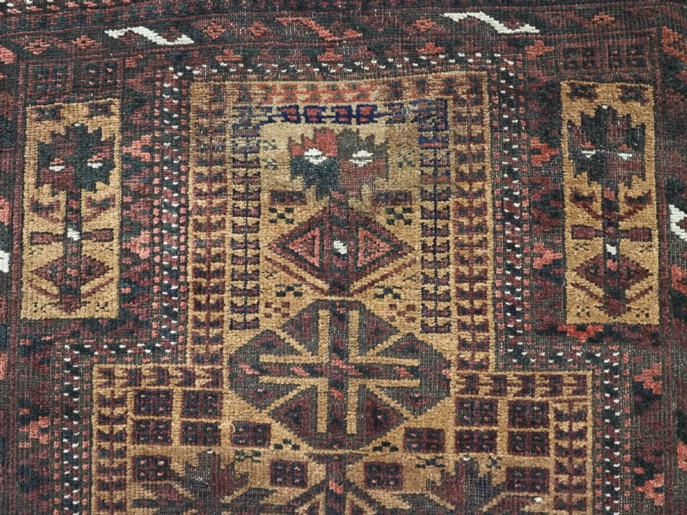 An antique woven Baluch prayer rug with a central tree of life design in camel brown and dark red tones. View VIII