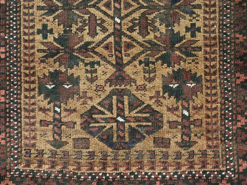 An antique woven Baluch prayer rug with a central tree of life design in camel brown and dark red tones. View IX