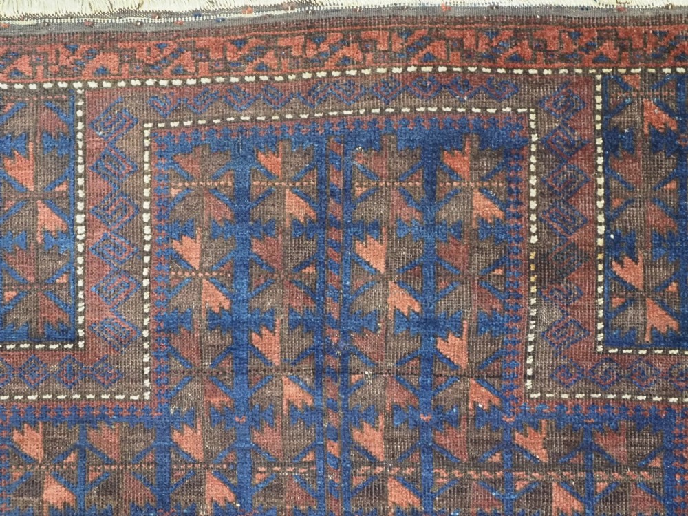 An antique Timuri Baluch wool prayer rug featuring a deep blue field woven with a repeating brown leaf motif and framed by geometric borders. View VII