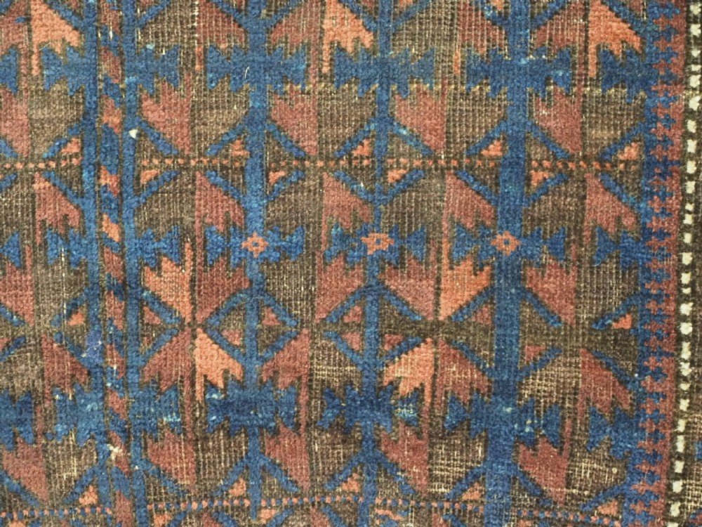 An antique Timuri Baluch wool prayer rug featuring a deep blue field woven with a repeating brown leaf motif and framed by geometric borders. View VIII