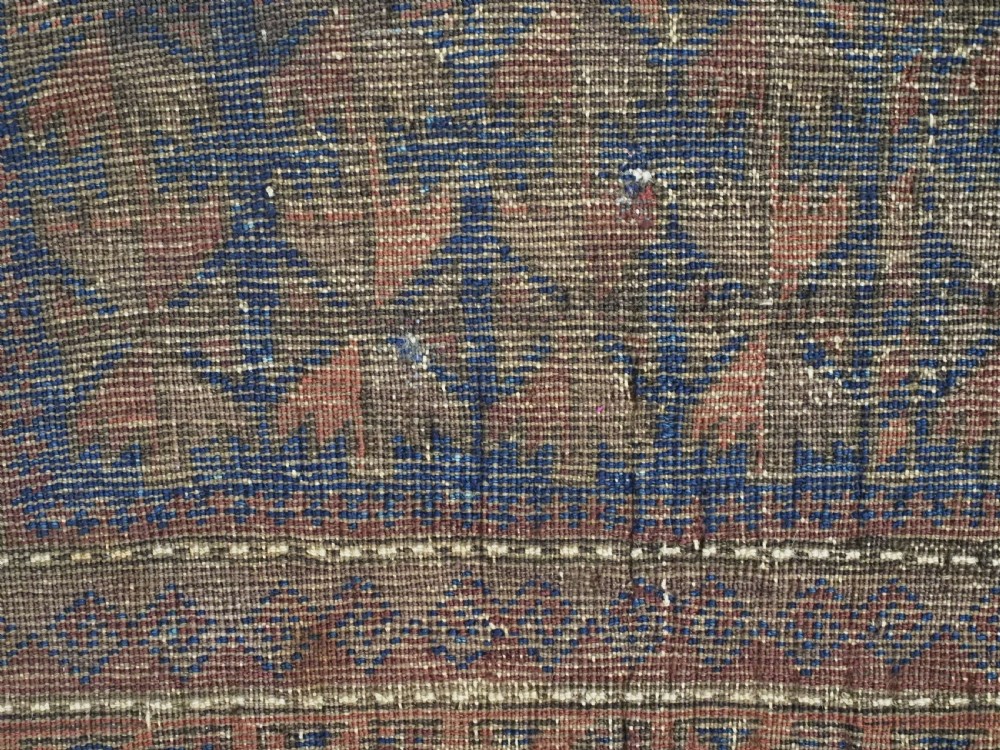 An antique Timuri Baluch wool prayer rug featuring a deep blue field woven with a repeating brown leaf motif and framed by geometric borders. View XI