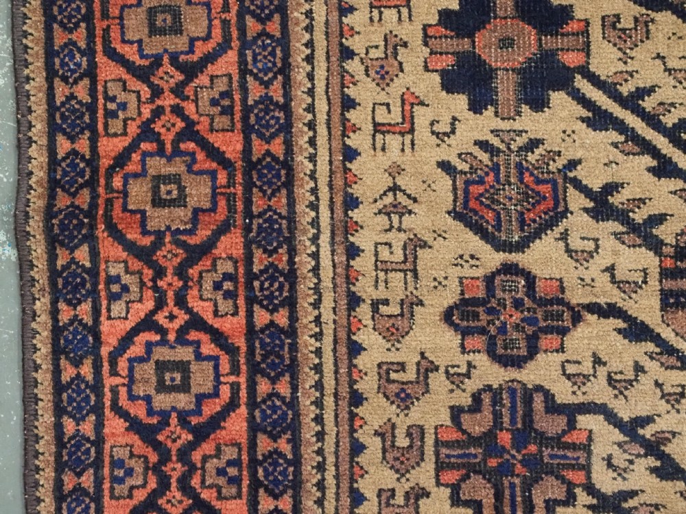 A rectangular late 19th-century Baluch tribal rug with a camel wool field, featuring a central stylised tree motif and terracotta geometric borders. View VII