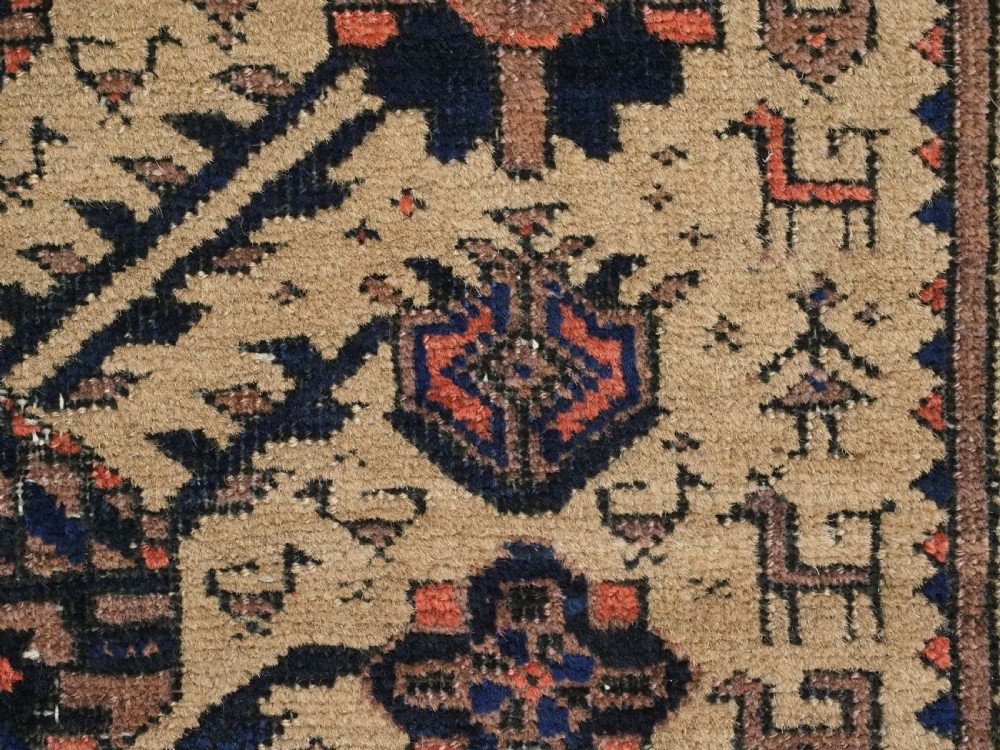 A rectangular late 19th-century Baluch tribal rug with a camel wool field, featuring a central stylised tree motif and terracotta geometric borders. View IX