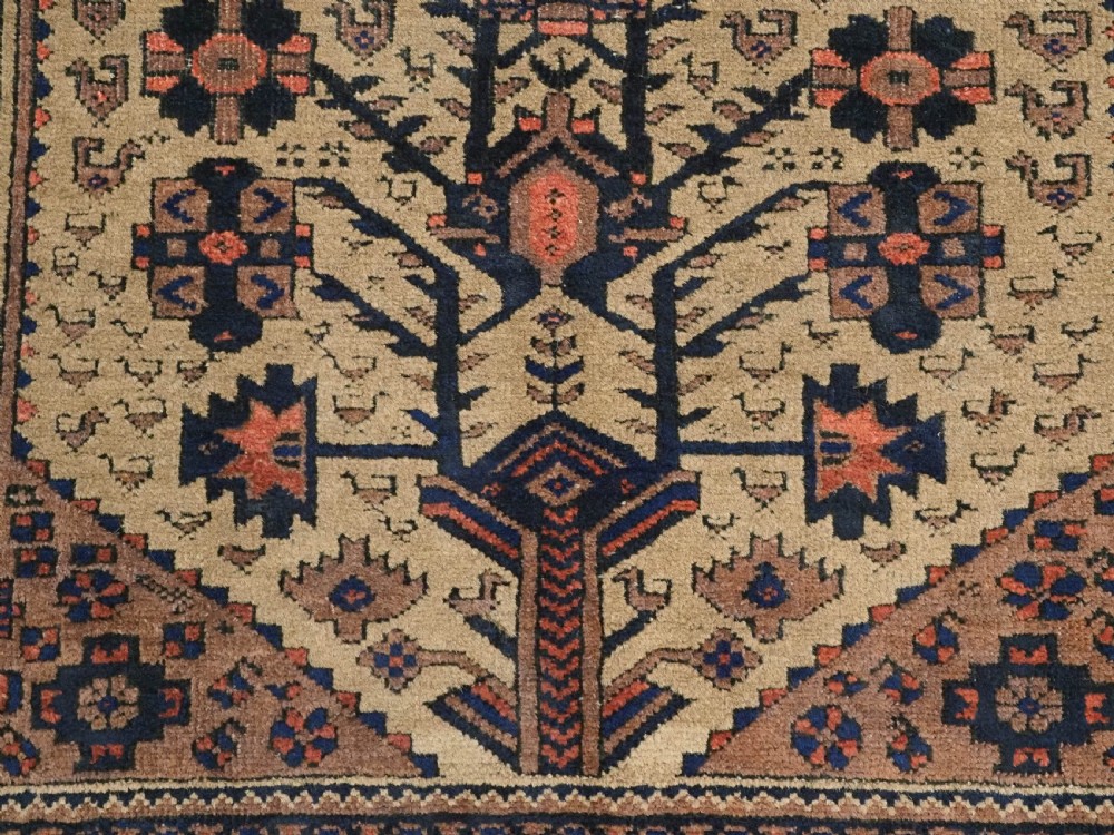 A rectangular late 19th-century Baluch tribal rug with a camel wool field, featuring a central stylised tree motif and terracotta geometric borders. View XI