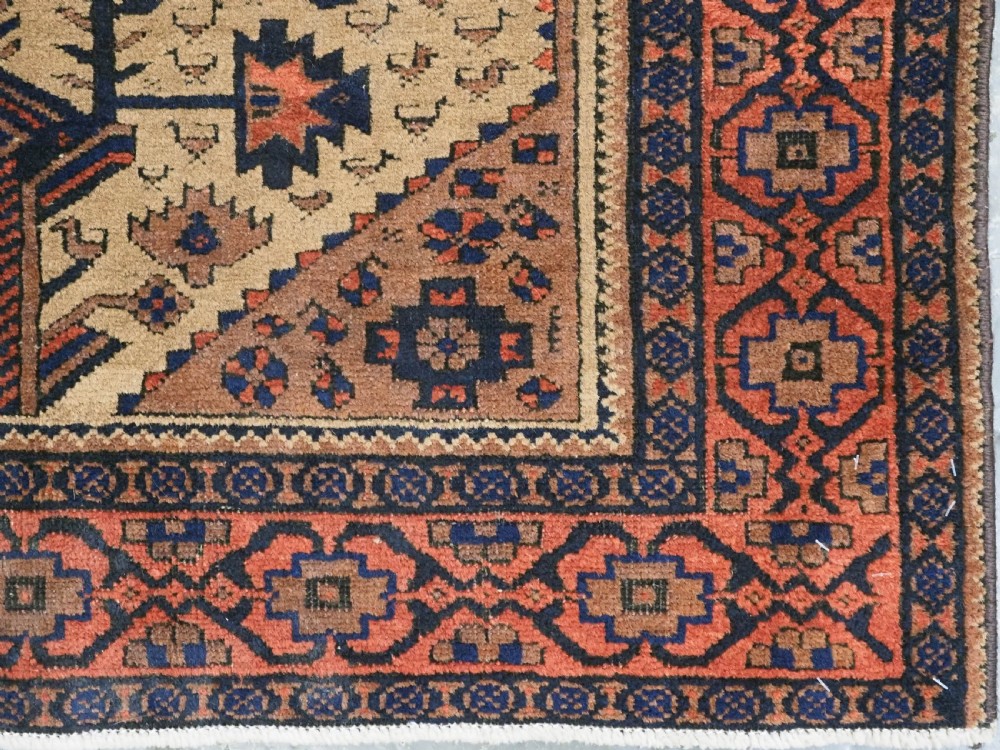 A rectangular late 19th-century Baluch tribal rug with a camel wool field, featuring a central stylised tree motif and terracotta geometric borders. View XII