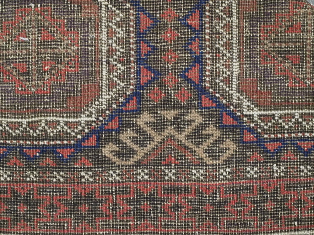An antique hand-knotted Salar Khani Baluch wool rug featuring a central column of octagonal geometric medallions framed by intricate patterned borders in dark brown, deep red, and navy blue tones. View XI