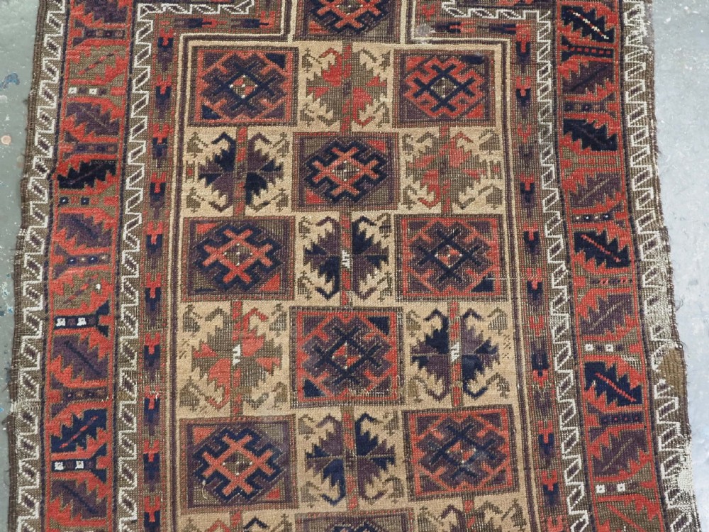 An antique hand-knotted wool prayer rug featuring a central mihrab pattern surrounded by geometric square motifs in dark brown, terracotta, and navy blue tones. View IV