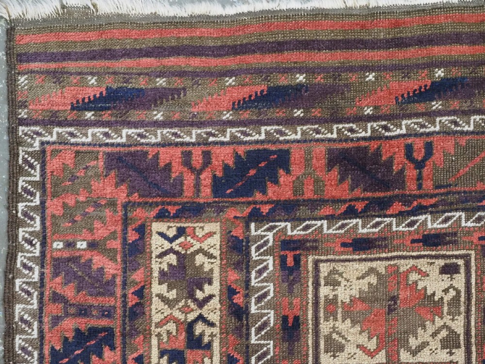 An antique hand-knotted wool prayer rug featuring a central mihrab pattern surrounded by geometric square motifs in dark brown, terracotta, and navy blue tones. View V
