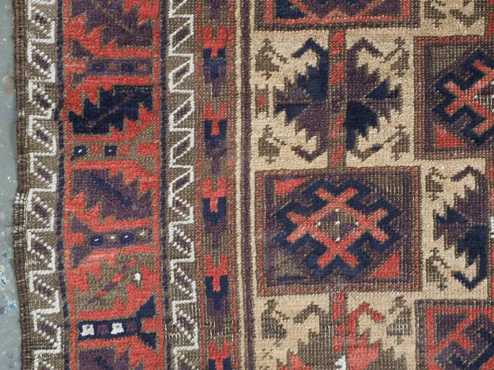 An antique hand-knotted wool prayer rug featuring a central mihrab pattern surrounded by geometric square motifs in dark brown, terracotta, and navy blue tones. View VI