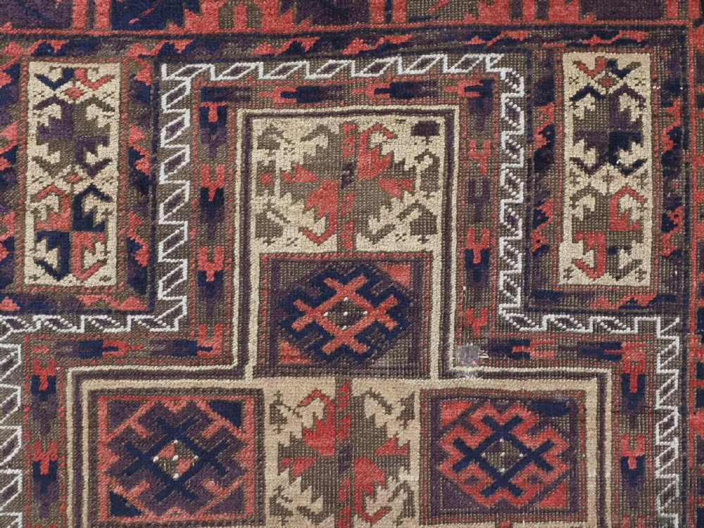 An antique hand-knotted wool prayer rug featuring a central mihrab pattern surrounded by geometric square motifs in dark brown, terracotta, and navy blue tones. View VII