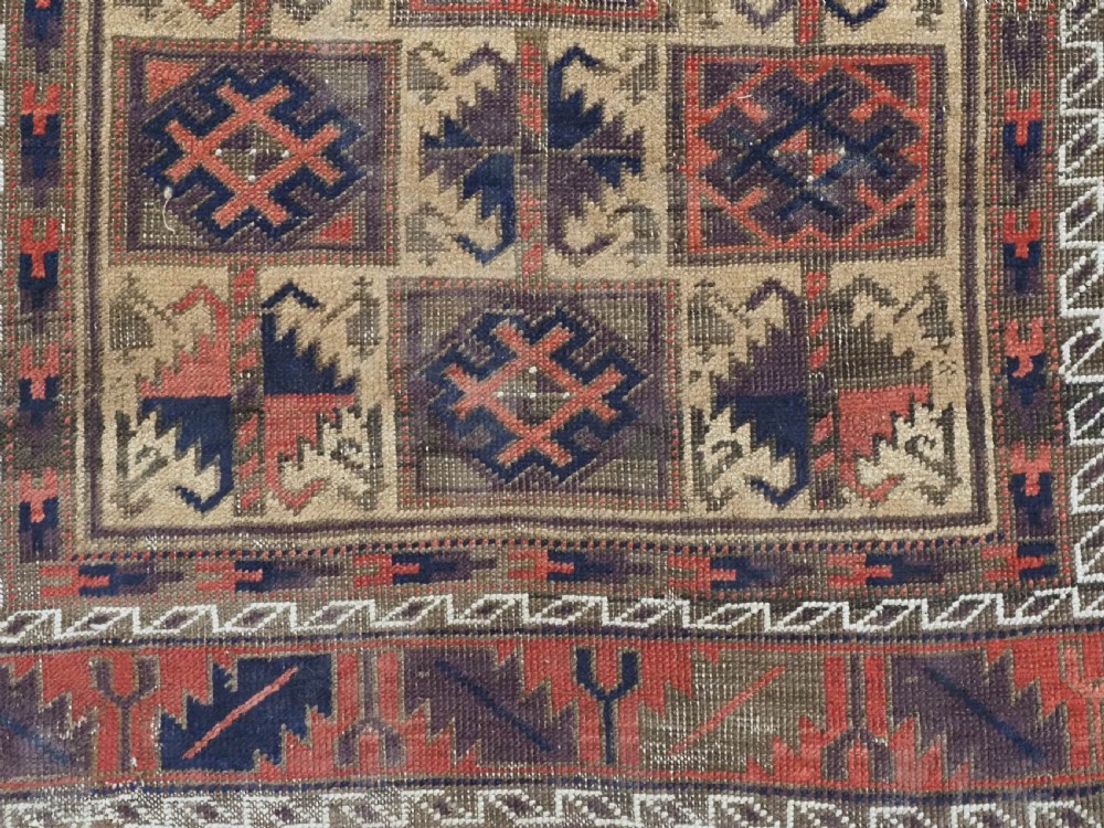 An antique hand-knotted wool prayer rug featuring a central mihrab pattern surrounded by geometric square motifs in dark brown, terracotta, and navy blue tones. View IX
