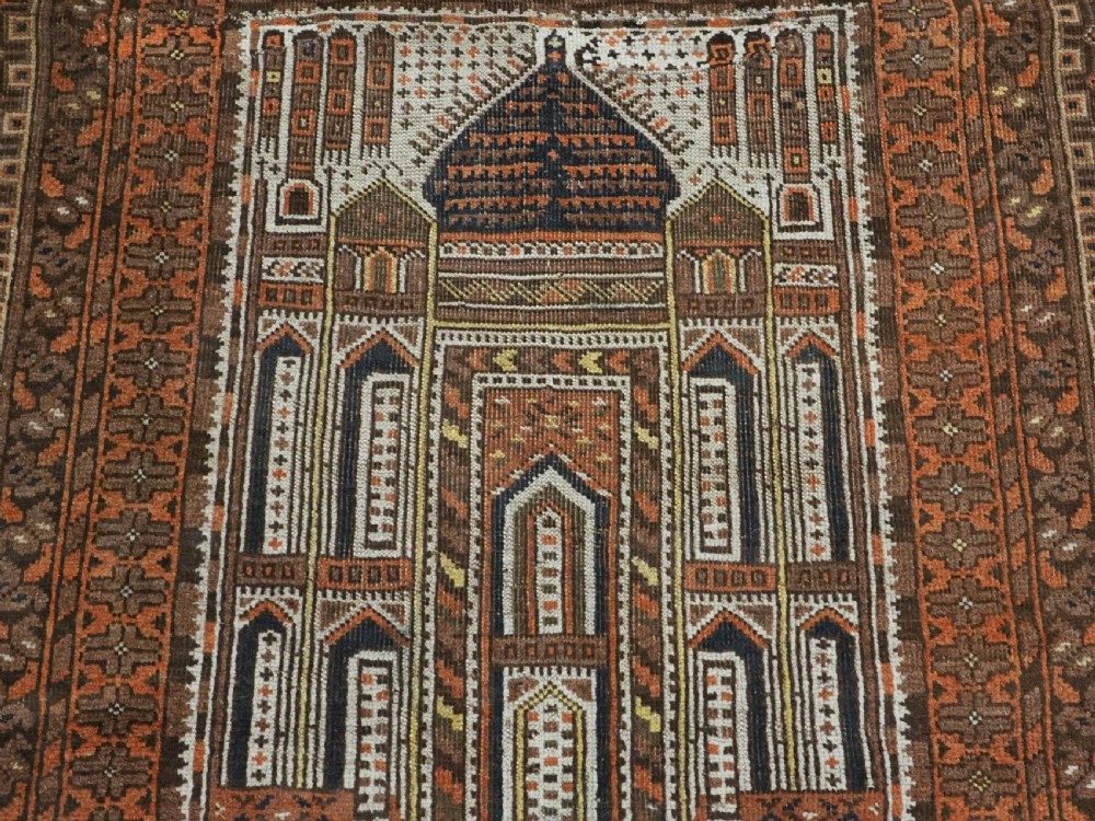 An antique Afghan Kizil Ayak hand-knotted wool rug featuring two opposing mosque niche designs in terracotta, brown, and ivory tones. View X