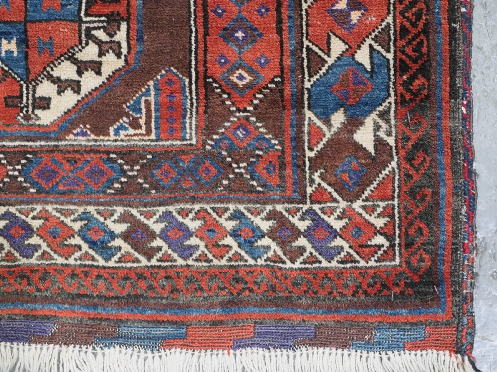 An antique long hand-knotted wool rug featuring geometric octagonal gul motifs in dark brown, red, blue, and cream tones. View XII