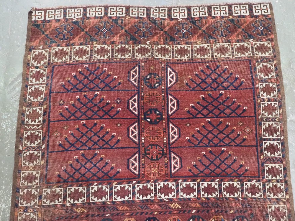 An antique Ersari Turkmen Ensi wool rug featuring a four-panel central field with tree-like motifs surrounded by geometric borders in rich shades of madder red, navy, and cream. View III