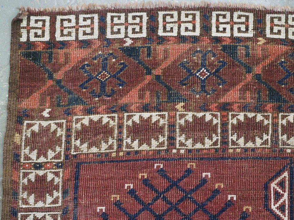 An antique Ersari Turkmen Ensi wool rug featuring a four-panel central field with tree-like motifs surrounded by geometric borders in rich shades of madder red, navy, and cream. View V