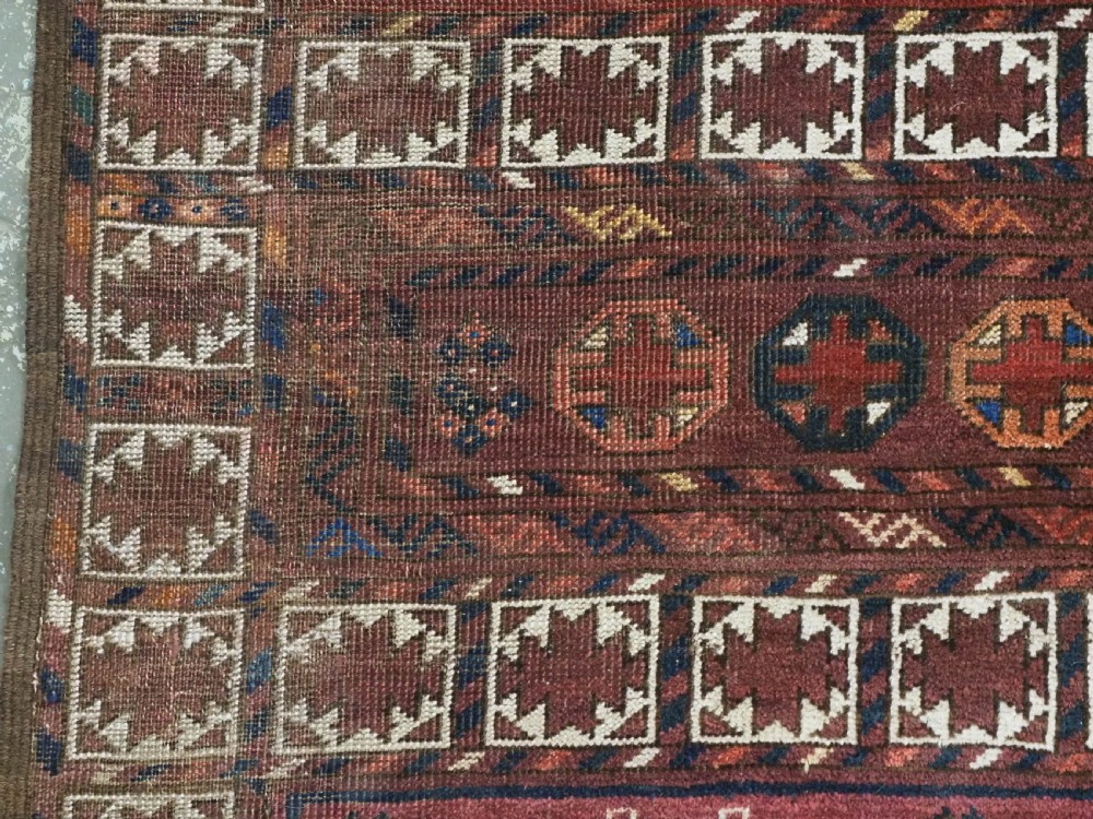 An antique Ersari Turkmen Ensi wool rug featuring a four-panel central field with tree-like motifs surrounded by geometric borders in rich shades of madder red, navy, and cream. View VII