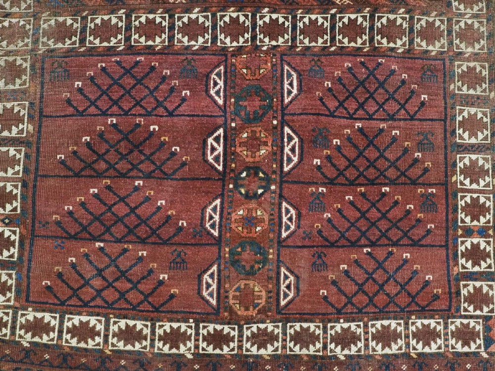 An antique Ersari Turkmen Ensi wool rug featuring a four-panel central field with tree-like motifs surrounded by geometric borders in rich shades of madder red, navy, and cream. View XI