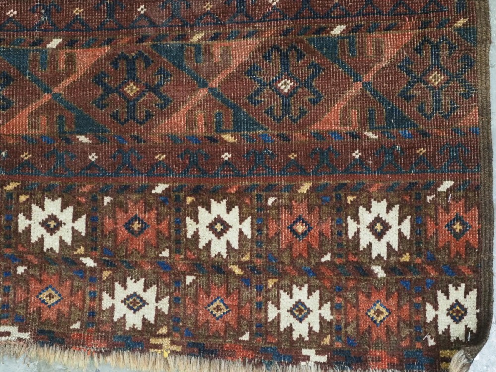 An antique Ersari Turkmen Ensi wool rug featuring a four-panel central field with tree-like motifs surrounded by geometric borders in rich shades of madder red, navy, and cream. View XIV