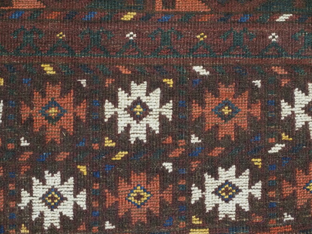An antique Ersari Turkmen Ensi wool rug featuring a four-panel central field with tree-like motifs surrounded by geometric borders in rich shades of madder red, navy, and cream. View XV