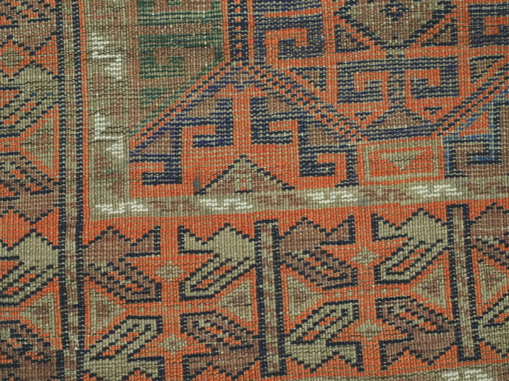 An antique Afghan Baluch wool rug featuring a repeating geometric hexagonal lattice pattern in terracotta orange, navy blue, sky blue, and sage green. View XII