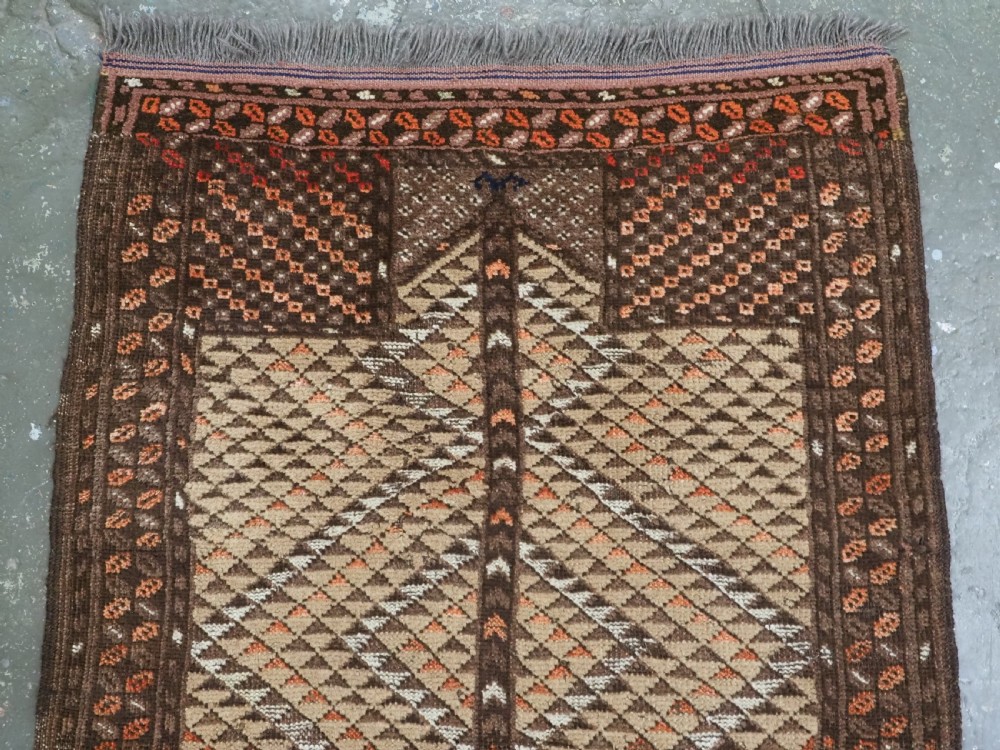 An antique hand-knotted Turkmen wool prayer rug featuring a dark brown and terracotta diamond lattice pattern with a prayer arch at the top. View III