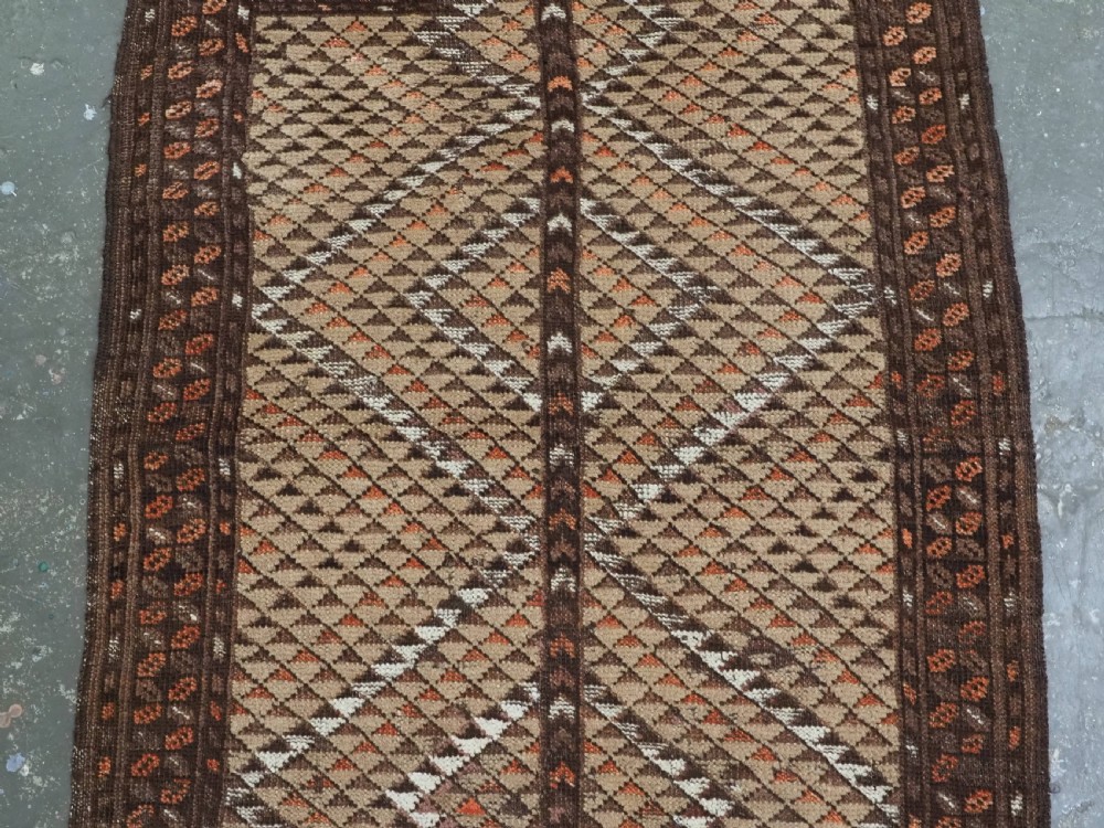 An antique hand-knotted Turkmen wool prayer rug featuring a dark brown and terracotta diamond lattice pattern with a prayer arch at the top. View IV