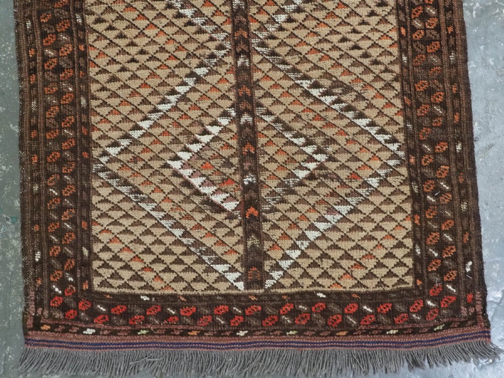 An antique hand-knotted Turkmen wool prayer rug featuring a dark brown and terracotta diamond lattice pattern with a prayer arch at the top. View V