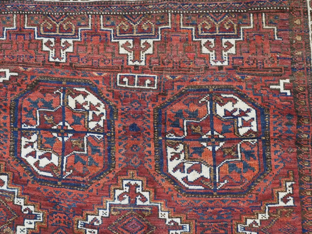 An antique hand-knotted wool rug featuring geometric octagonal medallions and diamond motifs in deep red, navy blue, and ivory tones. View VIII