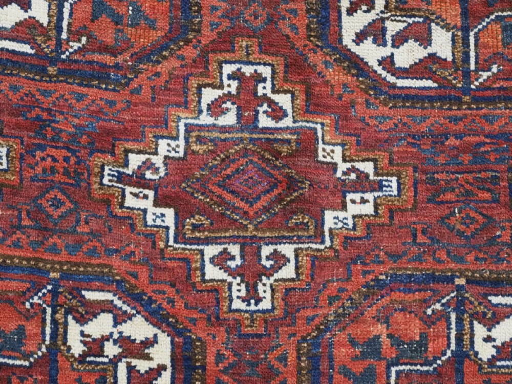 An antique hand-knotted wool rug featuring geometric octagonal medallions and diamond motifs in deep red, navy blue, and ivory tones. View IX