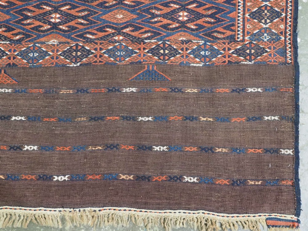 An antique Yomut Turkmen Soumak flatweave rug featuring an all-over geometric diamond lattice pattern in dark brown, terracotta, and navy blue. View XII