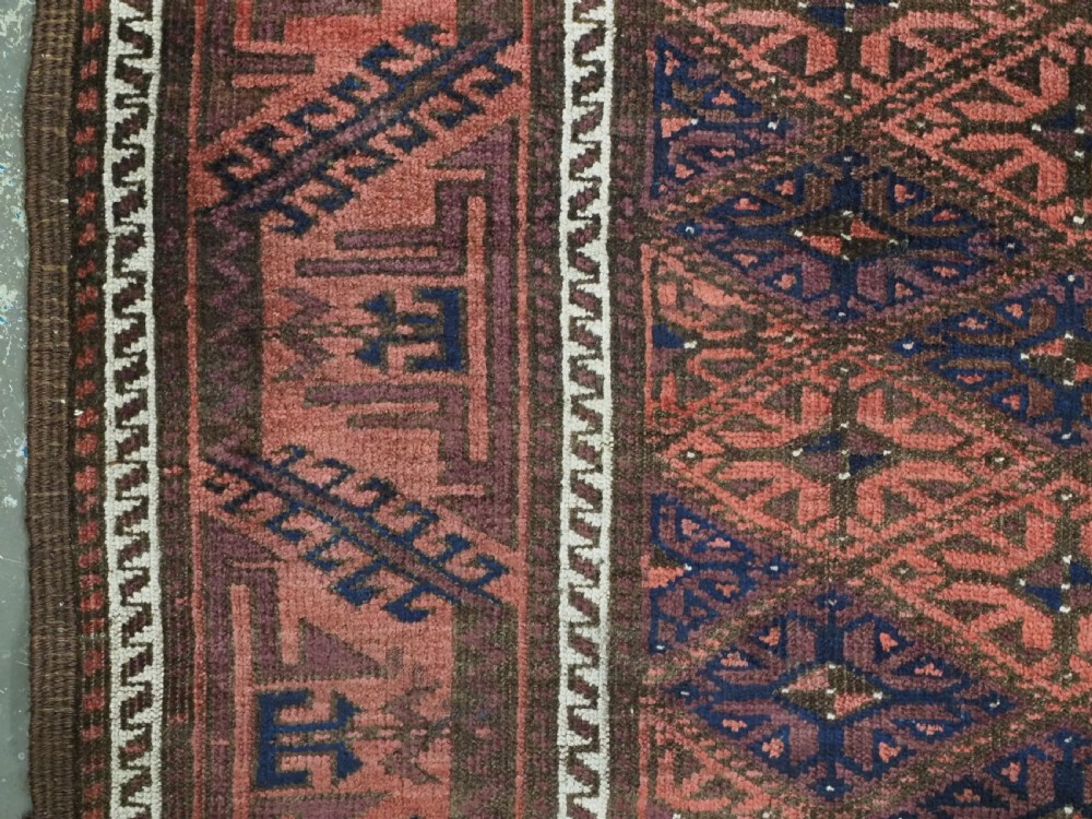 An antique 19th-century Khorasan Baluch wool rug featuring a repeating diamond calyx lattice pattern in rust red, dark navy, and brown with geometric borders. View VIII