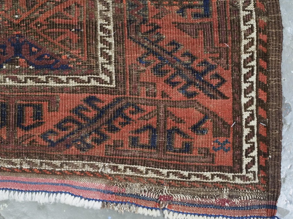 An antique 19th-century Khorasan Baluch wool rug featuring a repeating diamond calyx lattice pattern in rust red, dark navy, and brown with geometric borders. View XII