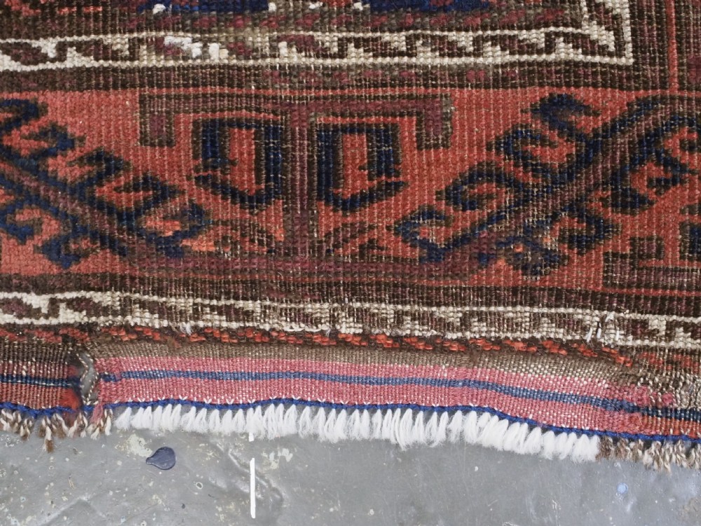 An antique 19th-century Khorasan Baluch wool rug featuring a repeating diamond calyx lattice pattern in rust red, dark navy, and brown with geometric borders. View XIII