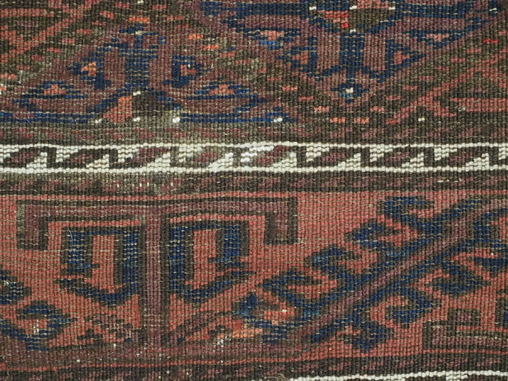 An antique 19th-century Khorasan Baluch wool rug featuring a repeating diamond calyx lattice pattern in rust red, dark navy, and brown with geometric borders. View XIV